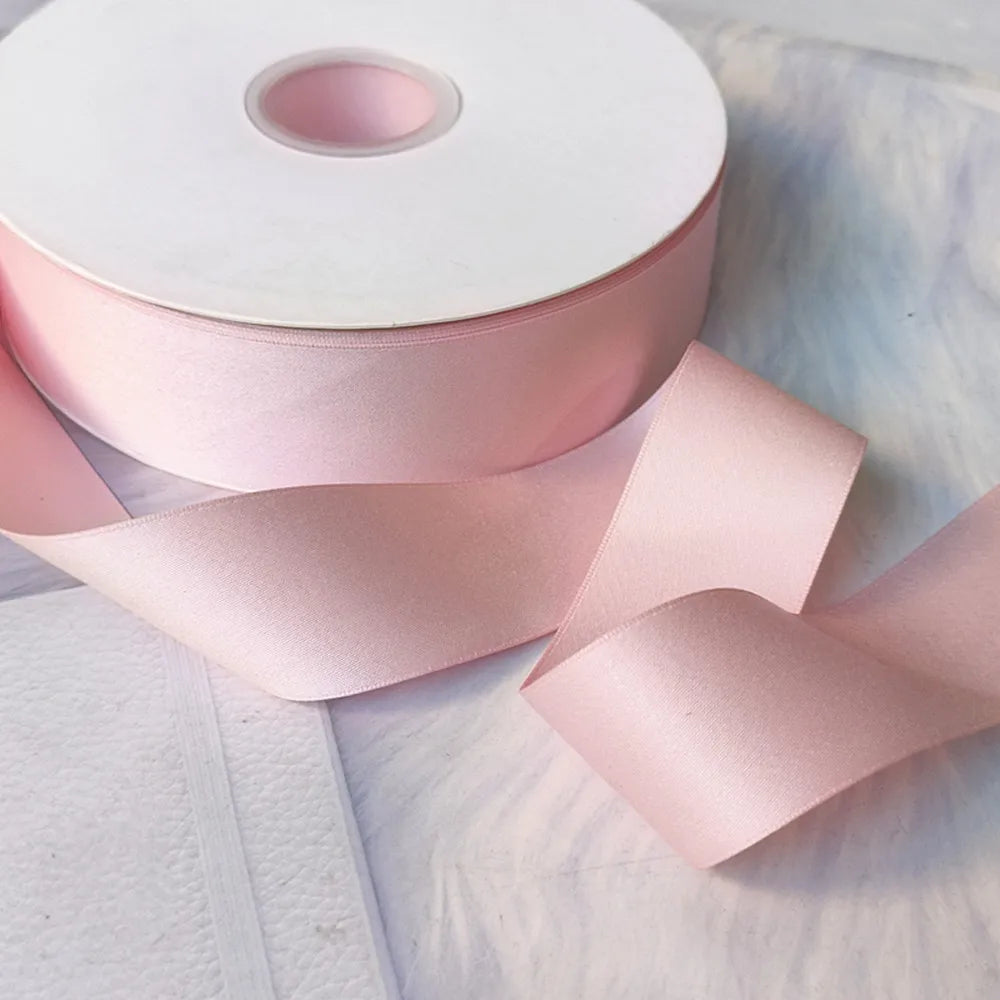 Roll of matte finish pink satin ribbon for crafts, wrapping, and decor