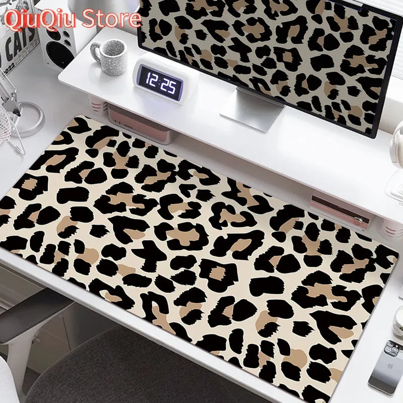 A large leopard print desk pad featuring black and tan spots, displayed on a white desk.