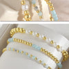 Gold-plated shell pearl beaded bracelets in various shades of white and light blue.