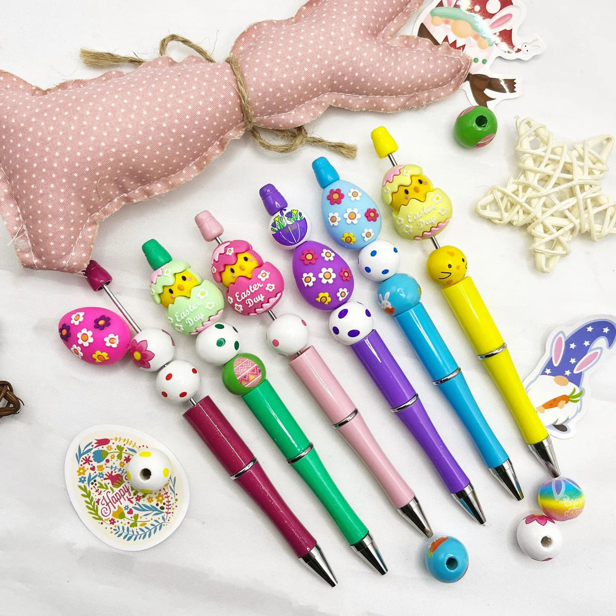 A set of rotating gradient acrylic beaded pens in various colors and shapes, displayed on a white surface.