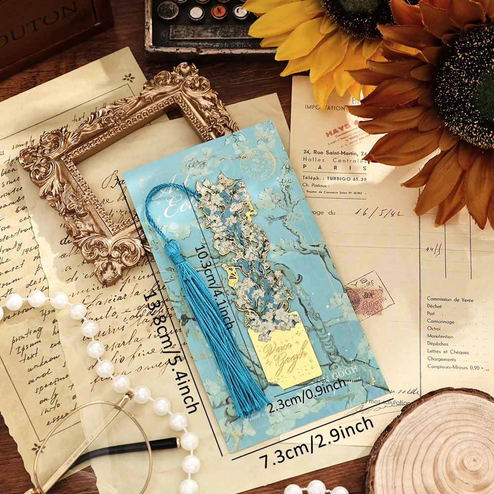 A vintage artistic metal bookmark with a blue tassel resting on aged paper.
