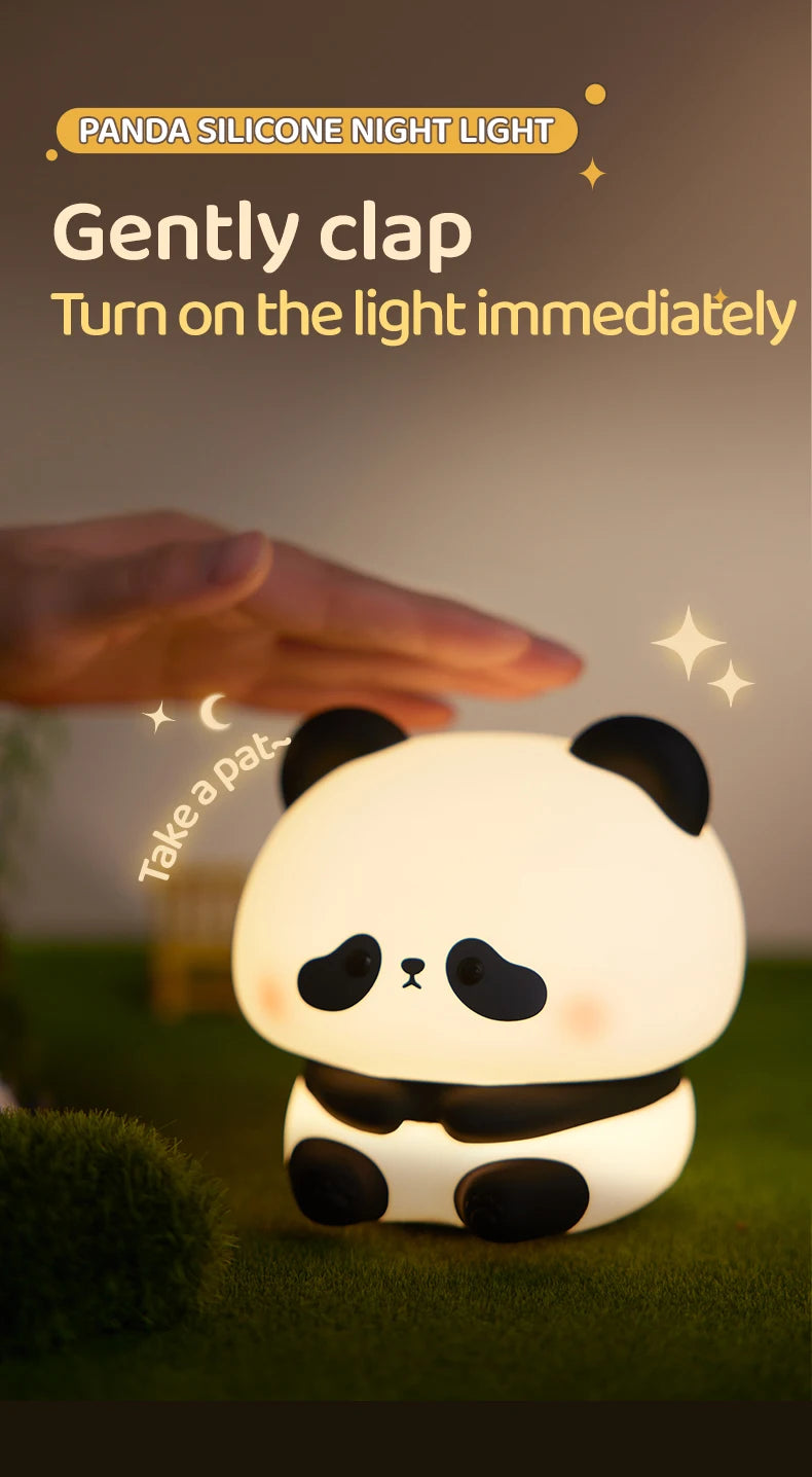 A white panda silicone night light is shown glowing on green grass, with a hand gently petting it.