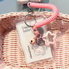 A pink beaded keychain attached to a crystal clear card holder resting in a woven basket.