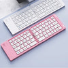 A pink foldable Bluetooth keyboard is shown open and closed on a light blue surface.