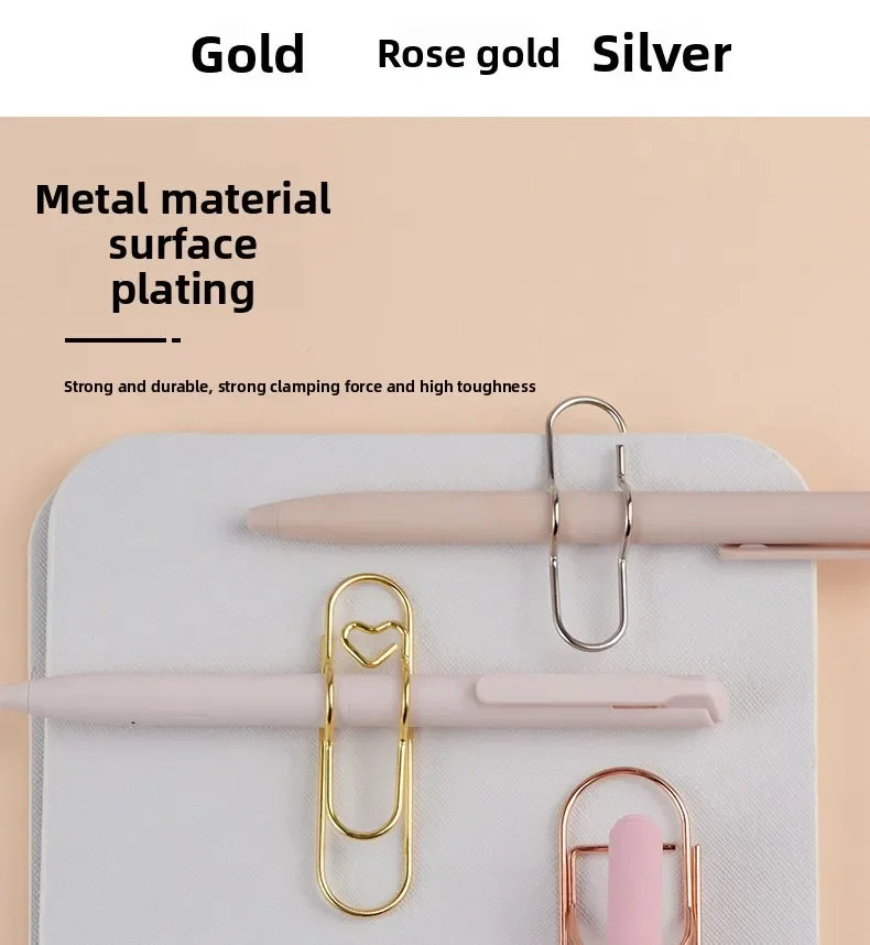 Elegant metal pen clips in gold, rose gold, and silver finishes displayed on a white surface.