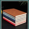 A stack of five premium brown leather journals or diaries lying on a dark surface.