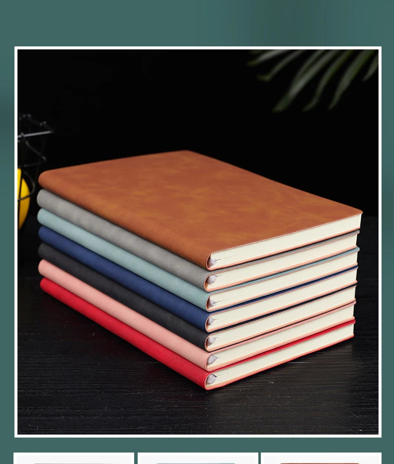 A stack of five premium brown leather journals or diaries lying on a dark surface.