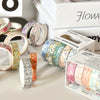 A collection of five rolls of floral patterned washi tape in various colors and designs displayed on a white surface.