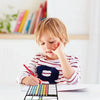 A young child is using a magnetic weekly chore chart for kids on a table.
