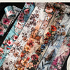 A collection of floral collage style decorative washi tape featuring various pink, red, and orange flowers on a light backgro