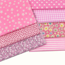 A stack of pink cotton patchwork fabric squares featuring various patterns including polka dots, gingham, and floral prints.