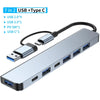 Silver multiport hub featuring USB 2.0, 3.0, PD 5W, and USB C ports with an attached cable.