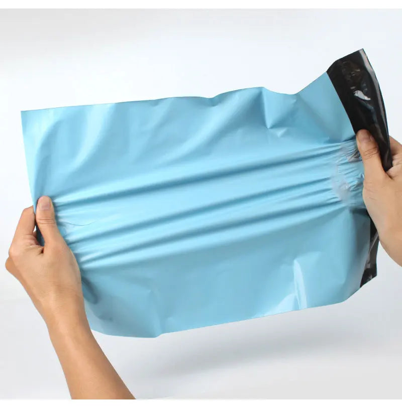 Hands holding a light blue reusable waterproof poly shipping bag.
