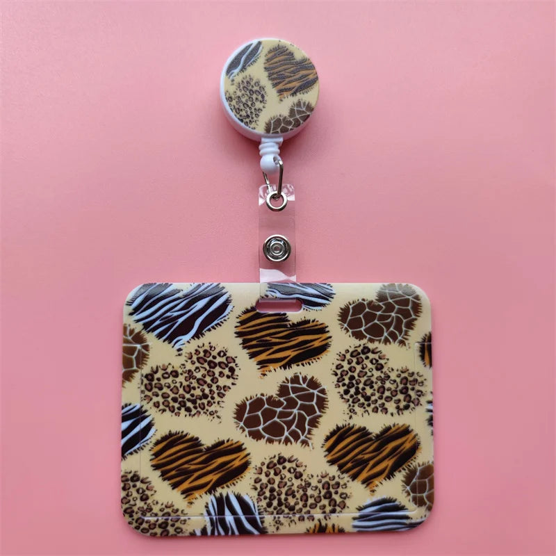 A leopard print card holder clip with a round holder and a rectangular case on a pink background.
