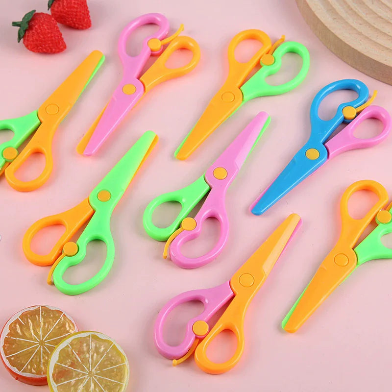 A collection of colorful two-tone plastic scissors in various shades of green, pink, and orange, displayed on a light backgro