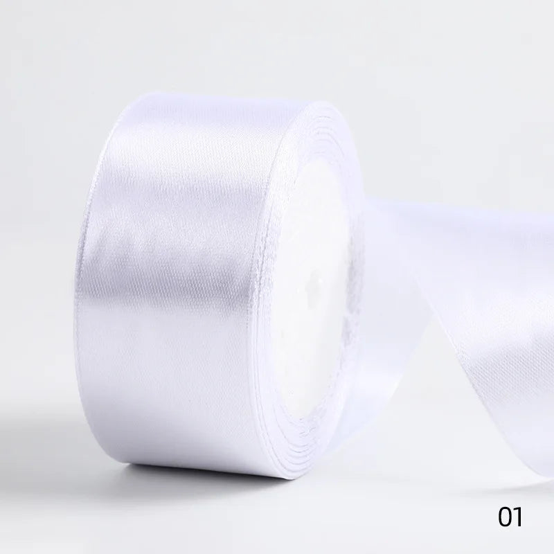 A roll of white satin ribbon used for gift wrapping and DIY crafts.