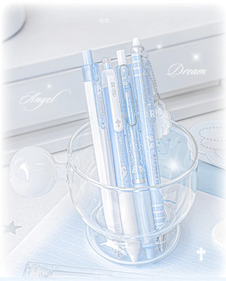 A set of four light blue Kawaii Pearl Angel gel pens in a glass bowl on a white surface.