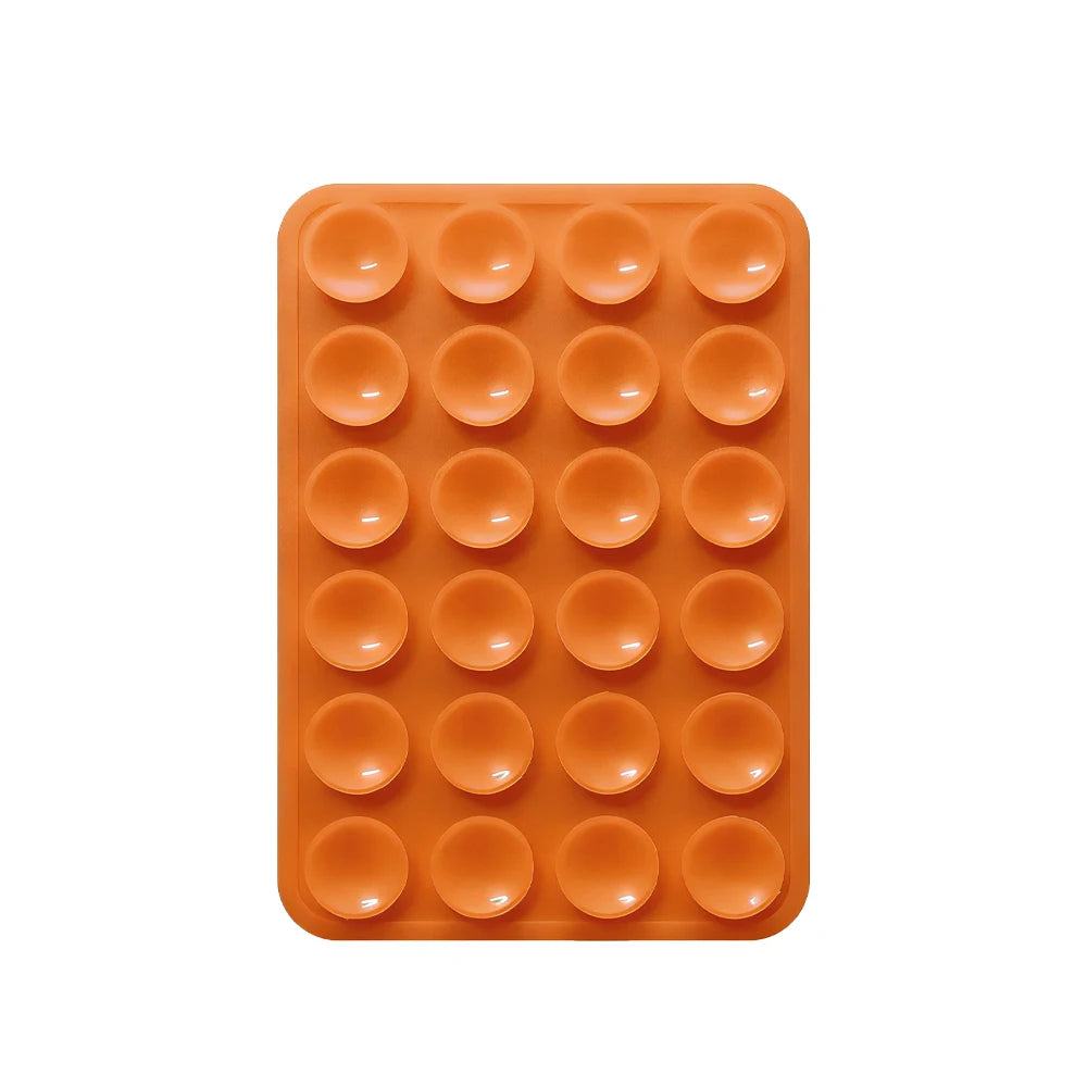 Sujetador de teléfono de silicona naranja con múltiples orificios circulares para montar dispositivos.