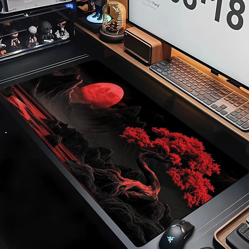 A large silicone gaming mouse pad is shown in a dark setup with a red moon and tree graphic.