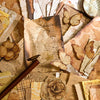 A collection of vintage paper, including aged parchment, textured cardstock, and dried flowers, used for crafting.