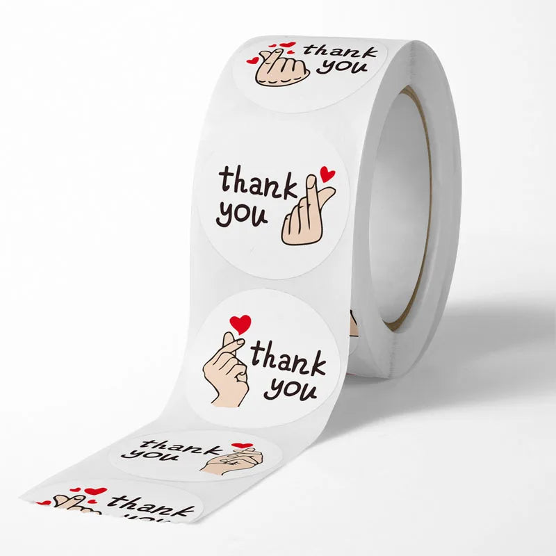 A roll of thank you stickers featuring hand gestures and the text thank you with red hearts.