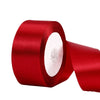A roll of vibrant red satin ribbon used for gift wrapping and DIY crafts.