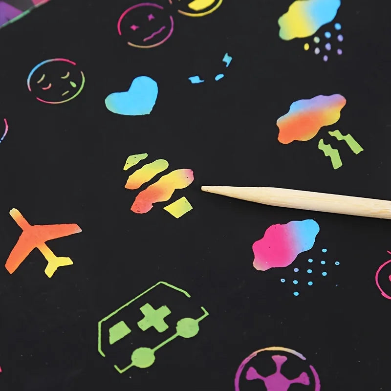 A black surface covered with colorful scratch-off art designs and a wooden stylus stick.