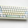 A close-up photo of a white mechanical keyboard featuring custom dye-sublimated PBT keycaps with cute animal designs.
