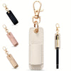 A beige leather pen holder keychain with a gold-tone clasp and a black leather strap.