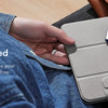 A hand holds a silver magnetic folio case for an iPad, demonstrating its scratch-resistant cover protection.