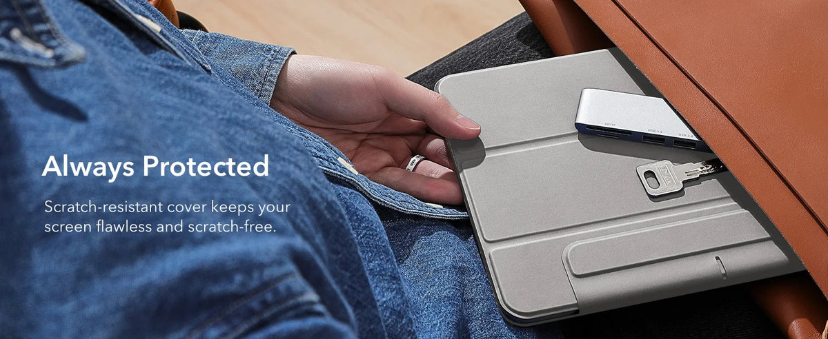 A hand holds a silver magnetic folio case for an iPad, demonstrating its scratch-resistant cover protection.