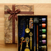 A wooden box containing a three-pen set with gold and silver fountain pens, ink, and wax seals, resting on an antique map.