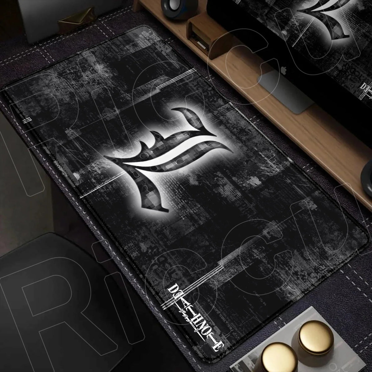 A black mouse pad featuring a stylized Death Note logo on a dark, textured background placed on a wooden desk.