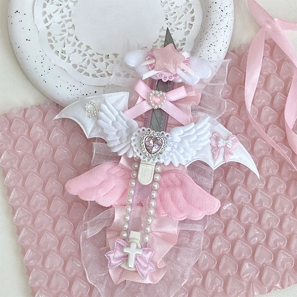 Rosa und weißer Engel-Flügel-Kunstmesser mit rosa Banddetails auf pinker, strukturierter Oberfläche