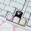 A close-up view of white mechanical keyboard keycaps featuring kawaii cat paw and pink heart designs.