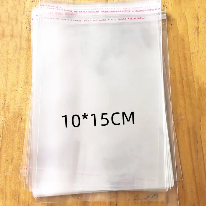 A stack of clear self-sealing plastic bags for jewelry, candy, and gifts is shown on a wooden surface.
