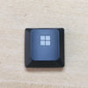 A black replacement keycap for a Dell Alienware AW510K keyboard, featuring a square white keycap design.