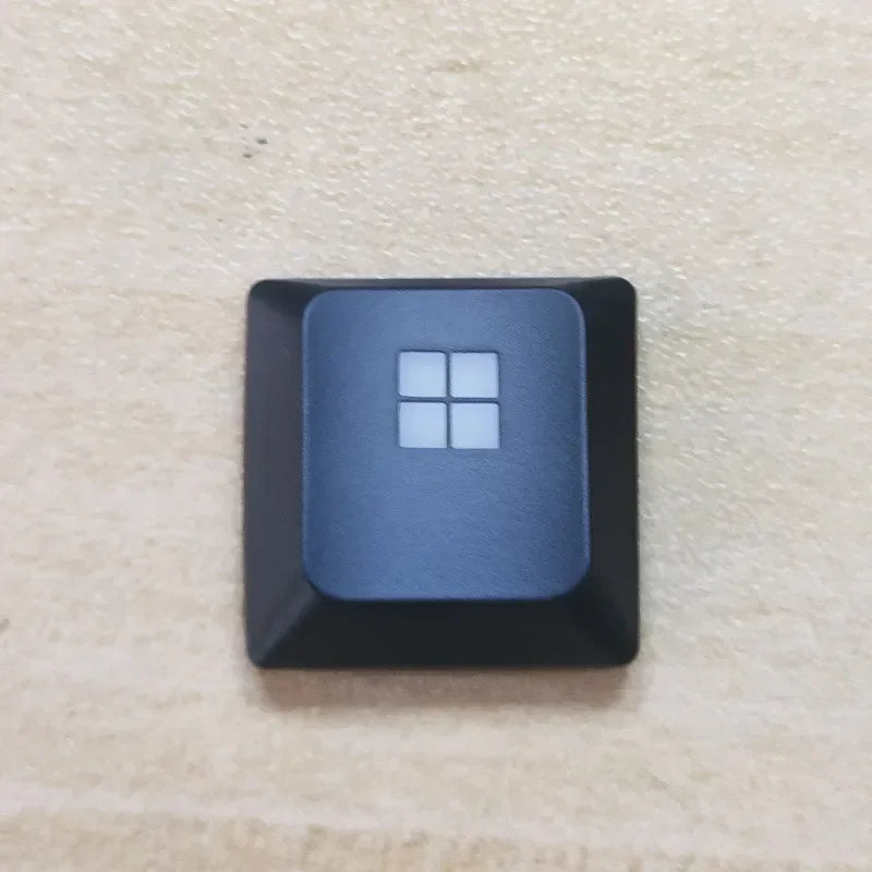 A black replacement keycap for a Dell Alienware AW510K keyboard, featuring a square white keycap design.