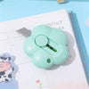A light green floral design letter opener and paper cutter tool resting on a monthly planner page.