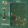 A dark green A5 notebook with gold foil illustrations of mountains, birds, and flowers on the cover.