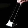 A hand is holding a piece of clear double-sided gap tape against a black background.