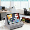A gray multi-angle adjustable tablet and phone holder resting on a white table in an office setting.