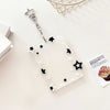 Pendentif de porte-photo en acrylique clair avec chaîne argentée et charms étoiles noir et blanc sur une surface blanche.