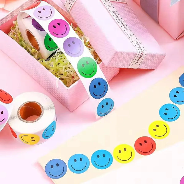 A collection of smiling face paper stickers in various colors and shapes arranged on pink packaging.