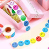 A collection of smiling face paper stickers in various colors and shapes arranged on pink packaging.