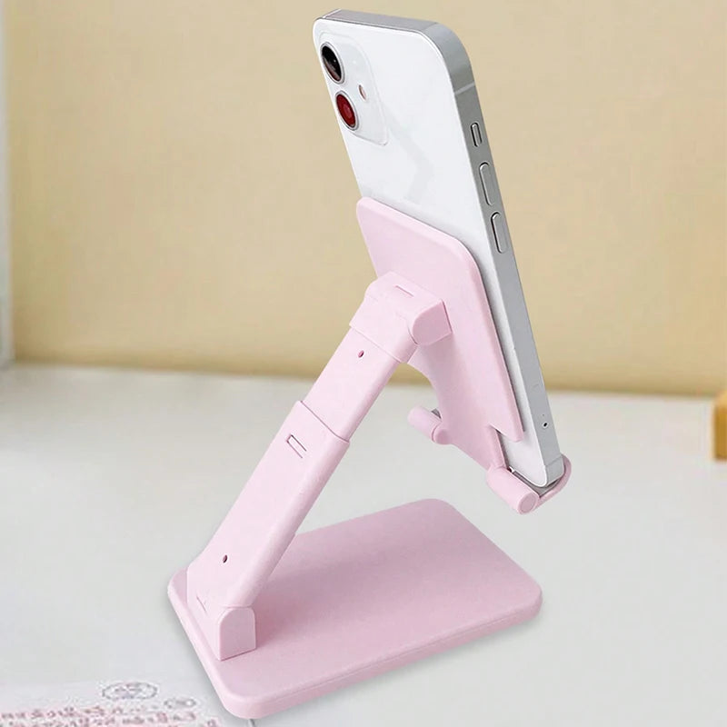 A pink adjustable desktop phone stand holding a white smartphone in a vertical position.