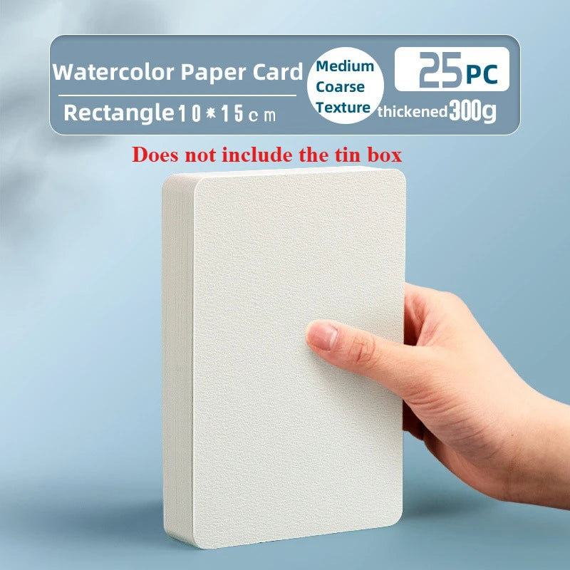 A hand holds a rectangular watercolor paper card set with a textured surface against a light blue background.