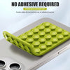 A green silicone suction cup phone back suction cup mount placed on a silver smartphone.