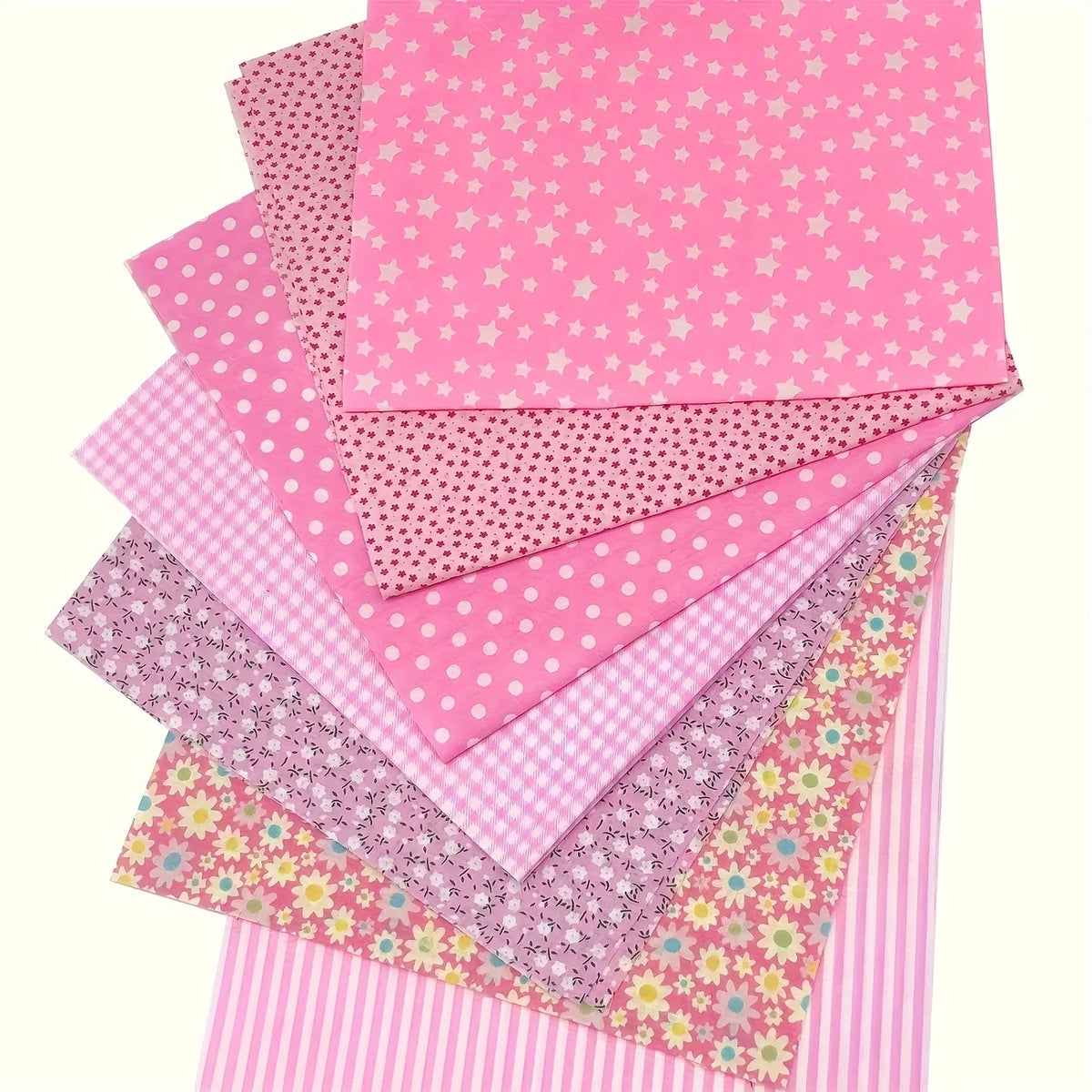 A stack of pink cotton patchwork fabric squares with various patterns including polka dots and stripes.