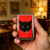 A vintage stainless steel card and cash case featuring a black cat face smoking a cigarette on a red background.